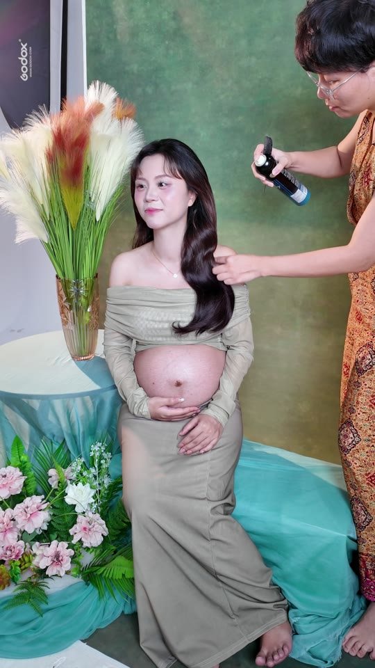 Xịt tóc, chỉnh váy, sửa từng ngón tay — mẹ bầu được chăm thế này trước khi chụp